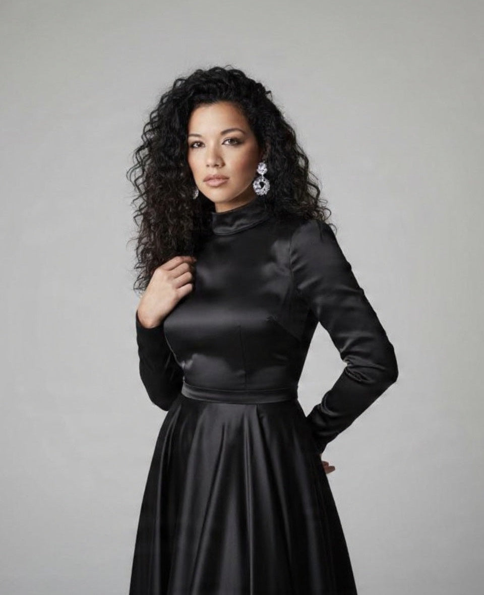 Woman wearing a black dress against a gray background