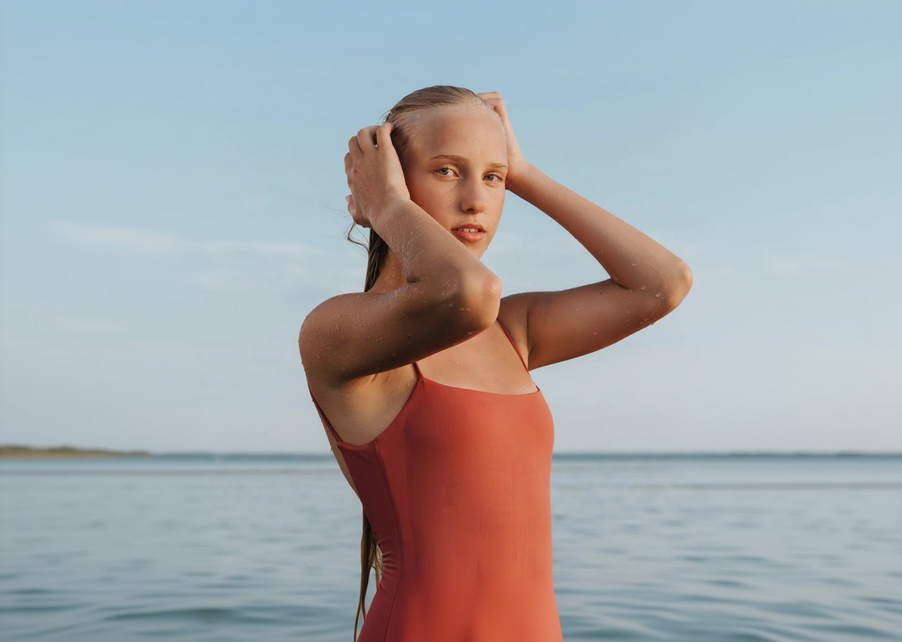 Person wearing a red swimsuit standing by the water