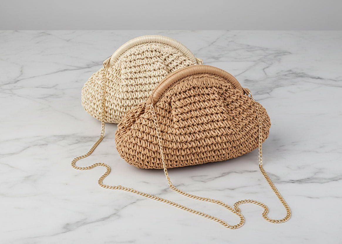 Two woven handbags on grass with a white fabric background
