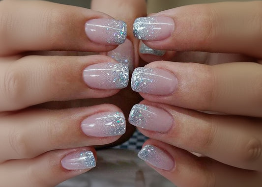Close-up of hands with pink nails and glittery silver tips.