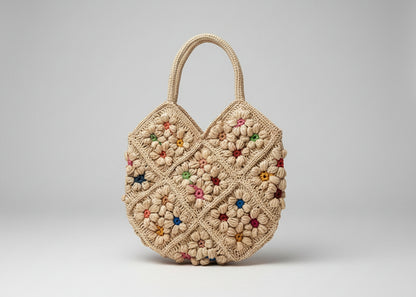 Crocheted bag with floral patterns on a white surface