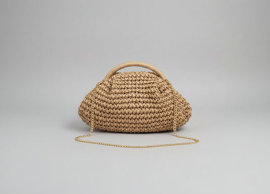 Woven handbag with a chain detail held by a person against a neutral background