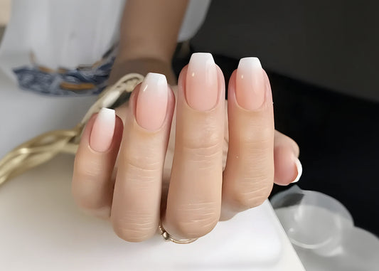 Close-up of a hand with gradient nail polish on a blurred background