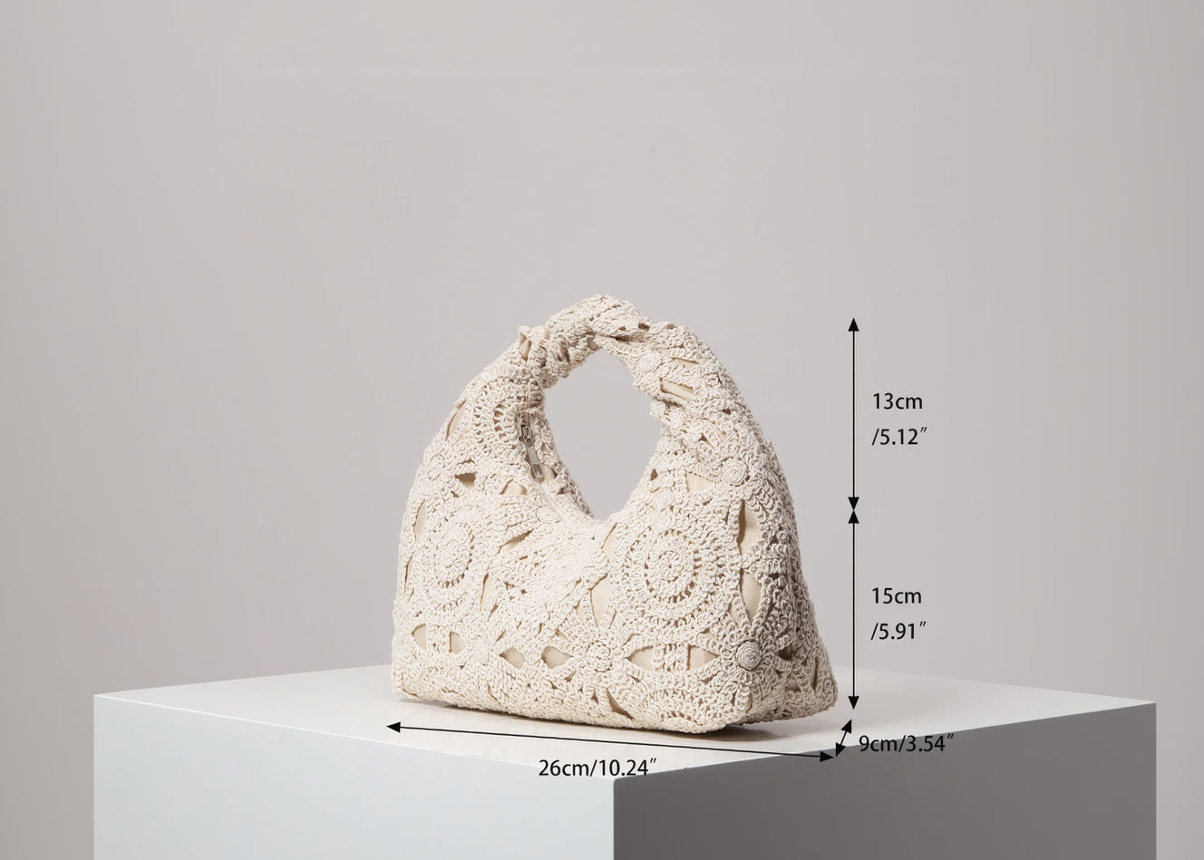 Beige crochet handbag with dimensions indicated on a gray background