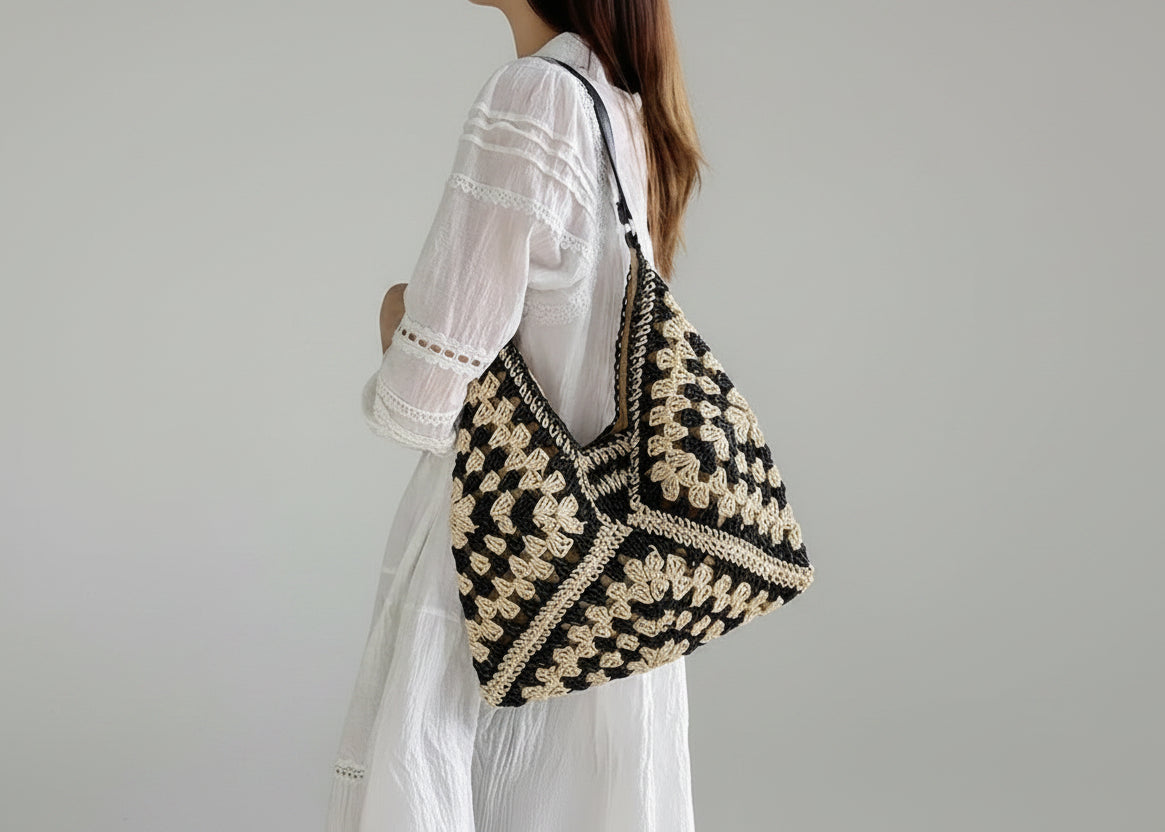 Person wearing a black and beige patterned bag indoors