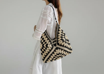 Person wearing a black and beige patterned bag indoors