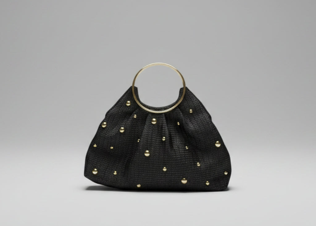 Black handbag with gold studs on a white background