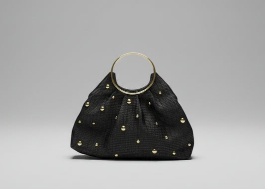 Black handbag with gold studs on a white background