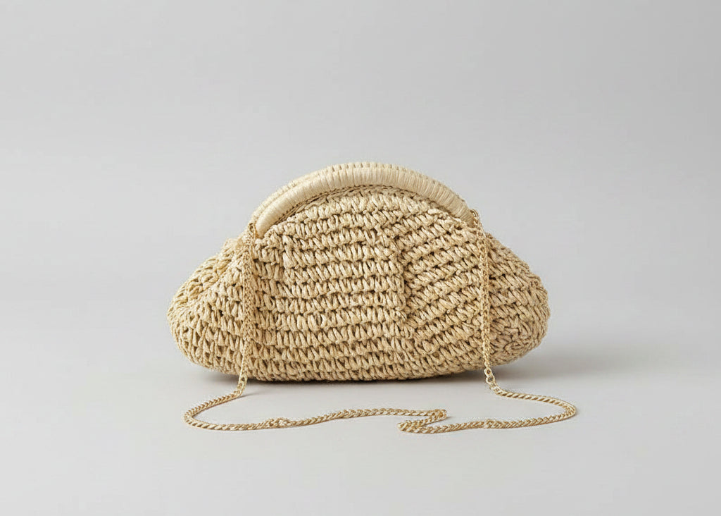 Hand holding a straw heart-shaped bag against a neutral background