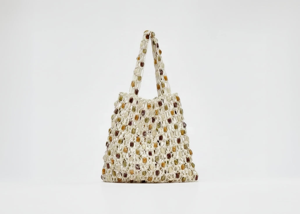 Woven handbag with a neutral color palette on a light gray background