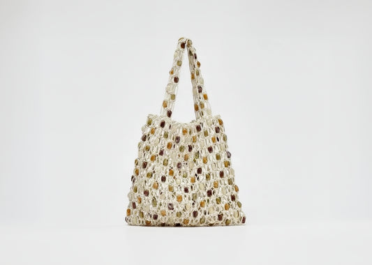 Woven handbag with a neutral color palette on a light gray background