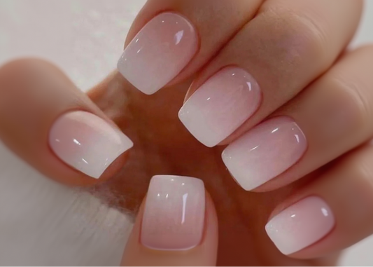 Close-up of a hand with pink and white gradient nail polish on a neutral background
