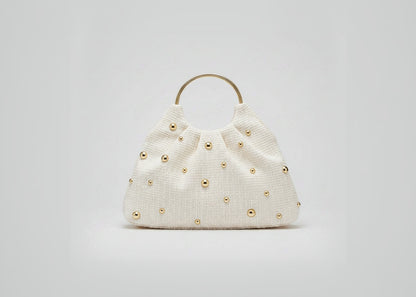 Beige handbag with gold studs on a white background