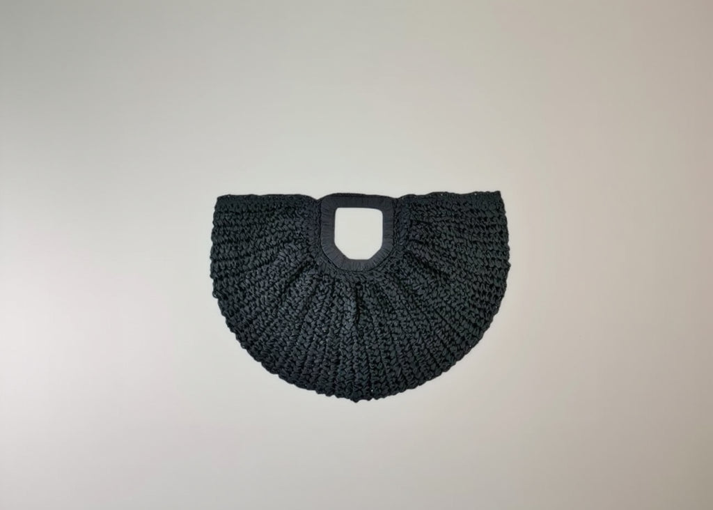 Black woven handbag on a light gray background