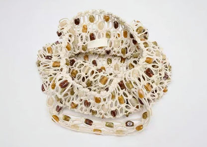 Netted produce bag with brown and green items on a white background